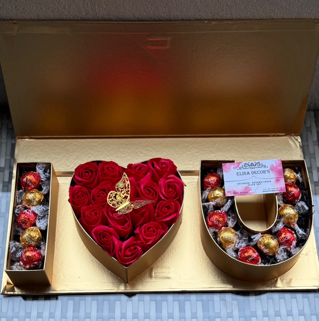 Box mit einem Rosenherz und Buchstaben aus Pralinen