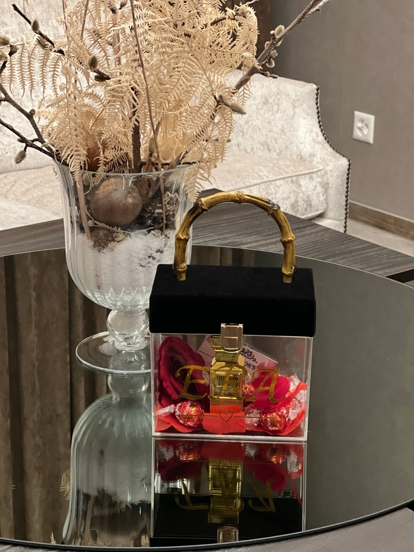 Schwarze Box mit goldenem Henkel und roten Rosen