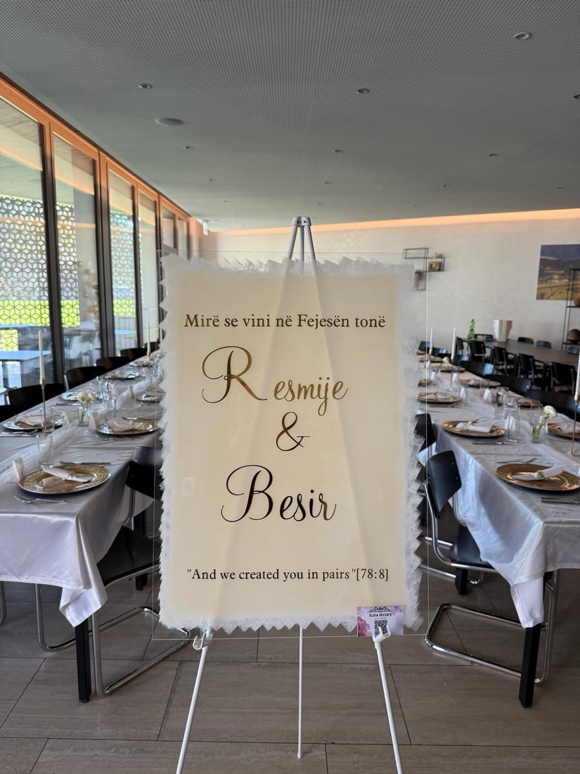 Willkommensschild mit den Namen des Brautpaars auf einer Staffelei im Festsaal